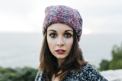 Portrait of young woman against sea