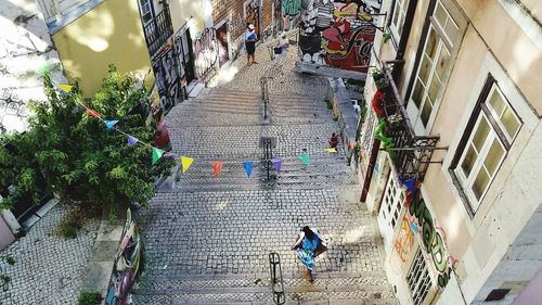 High angle view of people walking on staircase amidst buildings