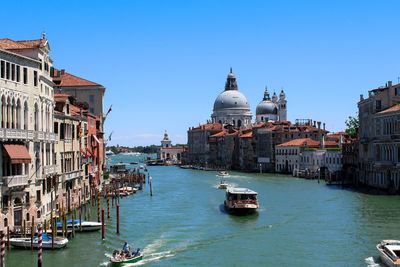 View of boats in canal with city in background