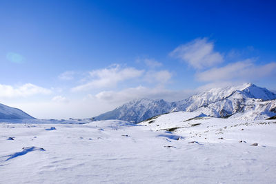 Scenic view of mountains against blue sky