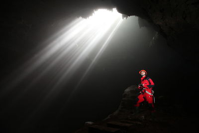 Man exploring underground cave at grubug jomblang cave yogyakarta