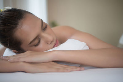 Close-up of young woman lying on massage table in spa