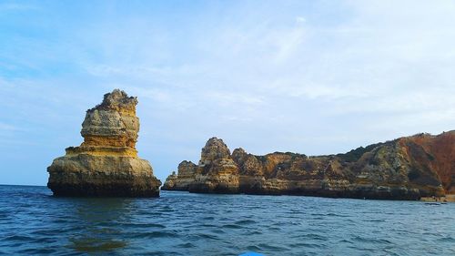 Rock formations in sea against sky
