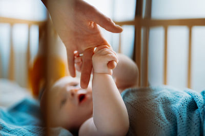 Low section of baby on bed at home