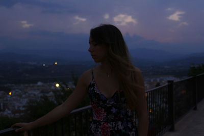 Woman standing against dramatic sky