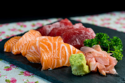 Close-up of sashimi on table against black background