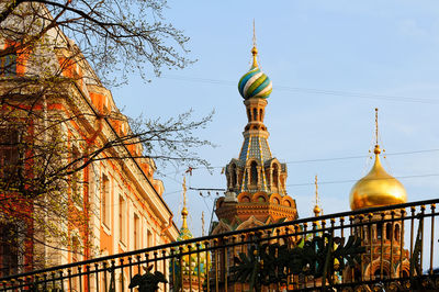 Low angle view of buildings and trees against sky