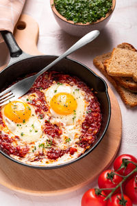 Traditional israel food eggs with tomatoes shakshouka in a pan close up