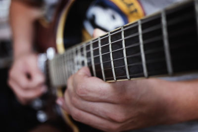 Midsection of man playing guitar