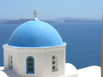 Blue sea by building against sky