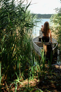 Rear view of woman sitting on grassy field