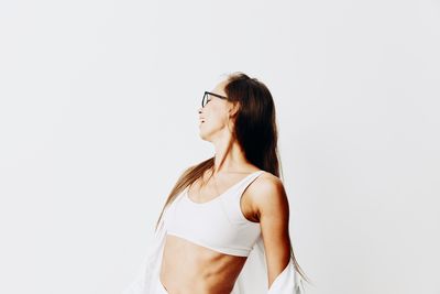 Young woman standing against white background