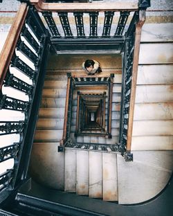 High angle view of woman standing on spiral stairs