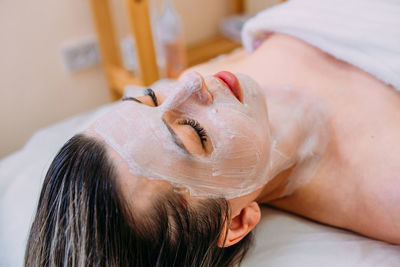 Close-up of woman lying on bed at home