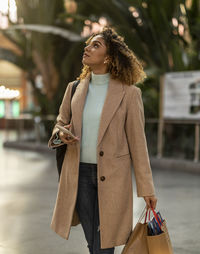 Woman holding mobile phone and shopping bags