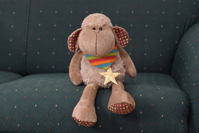 Close-up of toy sitting on sofa