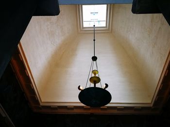 Low angle view of illuminated lighting equipment hanging on ceiling of building