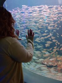 Portrait of young woman looking at aquarium