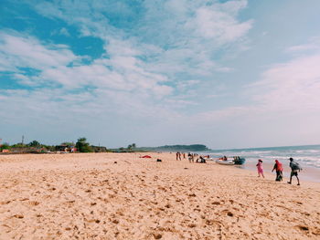 People on beach against sky