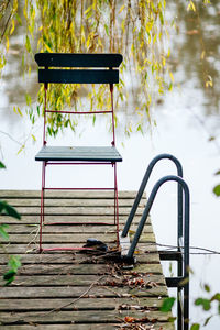 Empty chair on jetty in lake