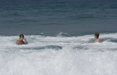 Father and son swimming in sea