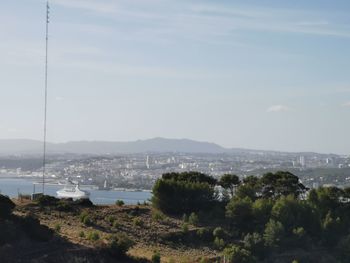 High angle view of city by sea against sky