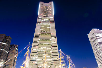 Low angle view of illuminated buildings against blue sky