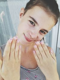 Close-up portrait of smiling girl showing nail art