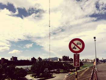 Information sign in city against cloudy sky