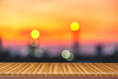 Defocused image of illuminated lights against orange sky