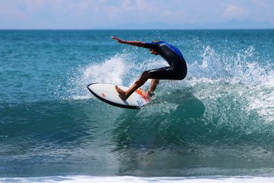 Side view of man in sea against sky