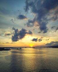 Scenic view of sea against dramatic sky during sunset