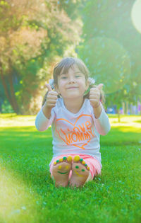 Portrait of cute girl playing with toy on grass