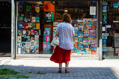 Rear view of woman walking on footpath in city