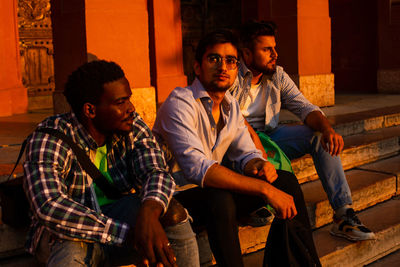 Young men sitting on steps during sunset