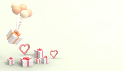 Heart shape made of balloons in box against white background