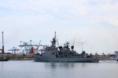 Warship at harbor against sky