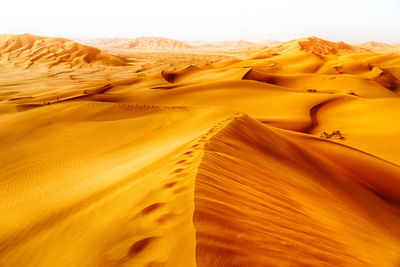 Sand dunes in desert against sky