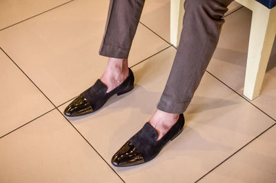 Low section of man sitting on tiled floor