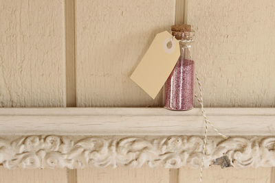 Close-up of glitter in glass jar with blank label on wooden frame