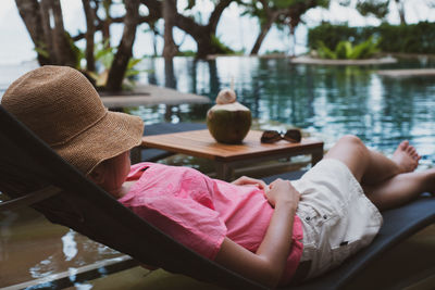 Midsection of woman sitting by lake