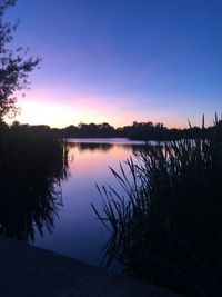 Scenic view of lake against sky at sunset
