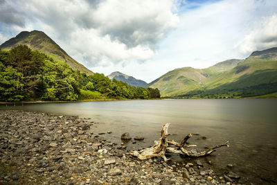 Scenic view of lake by mountains against sky