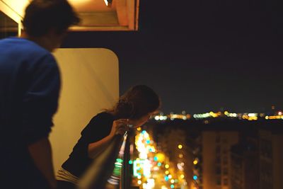 Woman standing in illuminated city at night