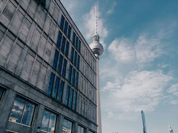Low angle view of modern building against cloudy sky
