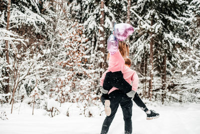 Full length of woman standing on snow covered land