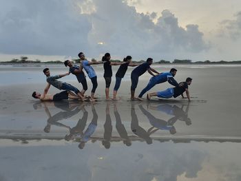 People on beach against sky