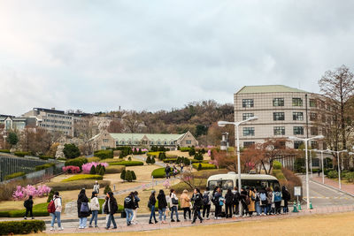 Group of people in park against buildings in city