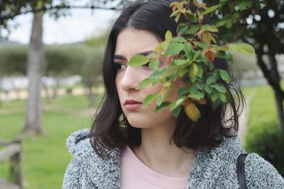 Close-up of young woman looking away at park