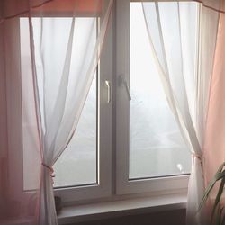 Close-up of white curtain hanging from window